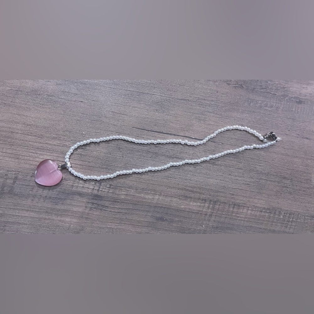 Handmade pearl necklace with pink heart charm.